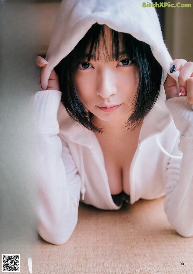 A woman in a white hoodie laying on the floor.