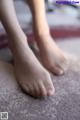 A close up of a person's bare feet on a carpet.