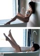 A woman sitting in a bathtub with her legs up in the air.