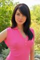 A woman in a pink shirt posing for a picture.