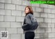 a woman standing in front of a brick wall