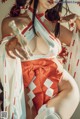 A woman in a red and white kimono posing for a picture.