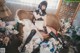 A woman sitting on a couch surrounded by flowers.