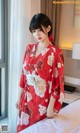 a woman in a red kimono standing on a bed