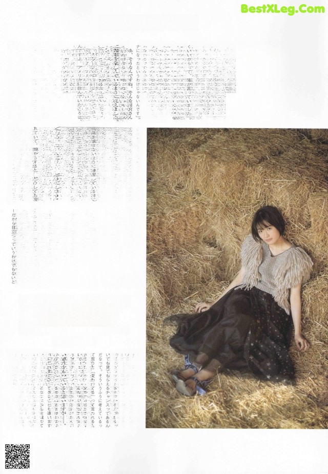 A woman sitting on a pile of hay in a magazine.