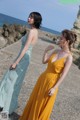 Two women standing next to each other on a beach.