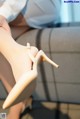 A close up of a woman's legs wearing a pair of nude colored shoes.