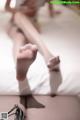 A woman laying on top of a bed with her feet up.